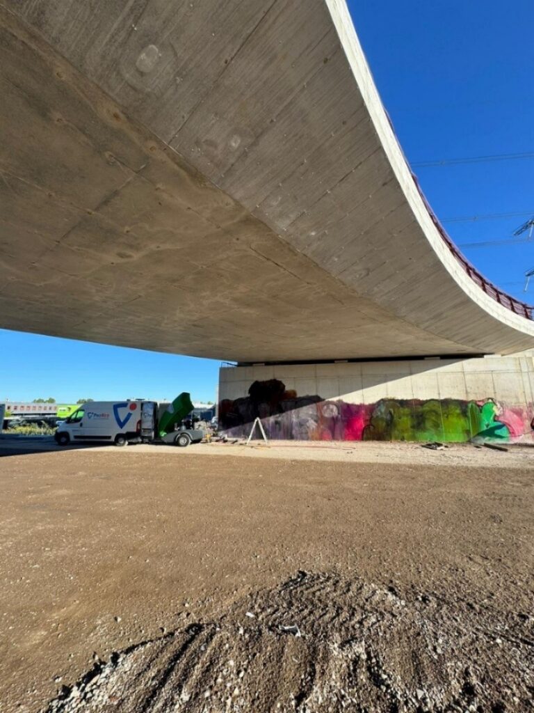 Tijdens het verwijderen van graffiti op betonnen wand