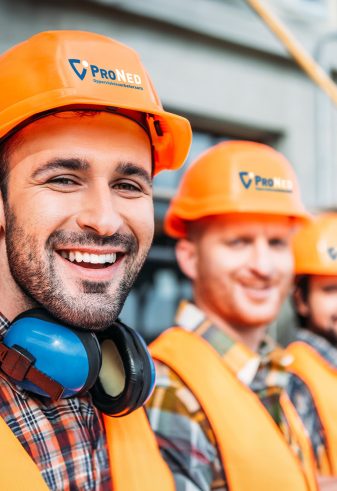 close-up shot of group of equipped builders looking at camera at construction site