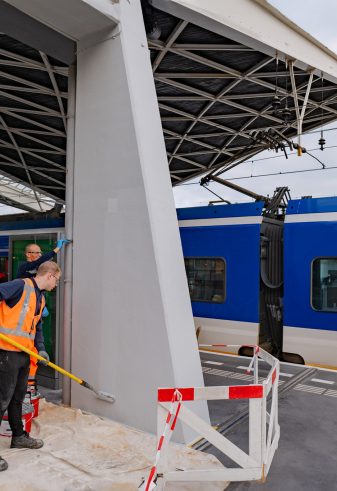 Het Keimen van betonnen pilaren op een perron bij station Tilburg