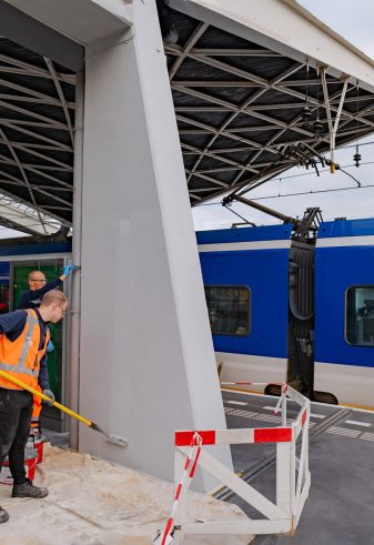 Het Keimen van betonnen pilaren op een perron bij station Tilburg