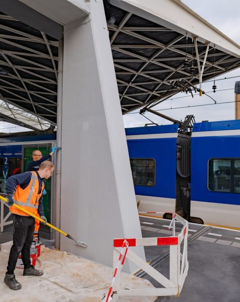 Het Keimen van betonnen pilaren op een perron bij station Tilburg